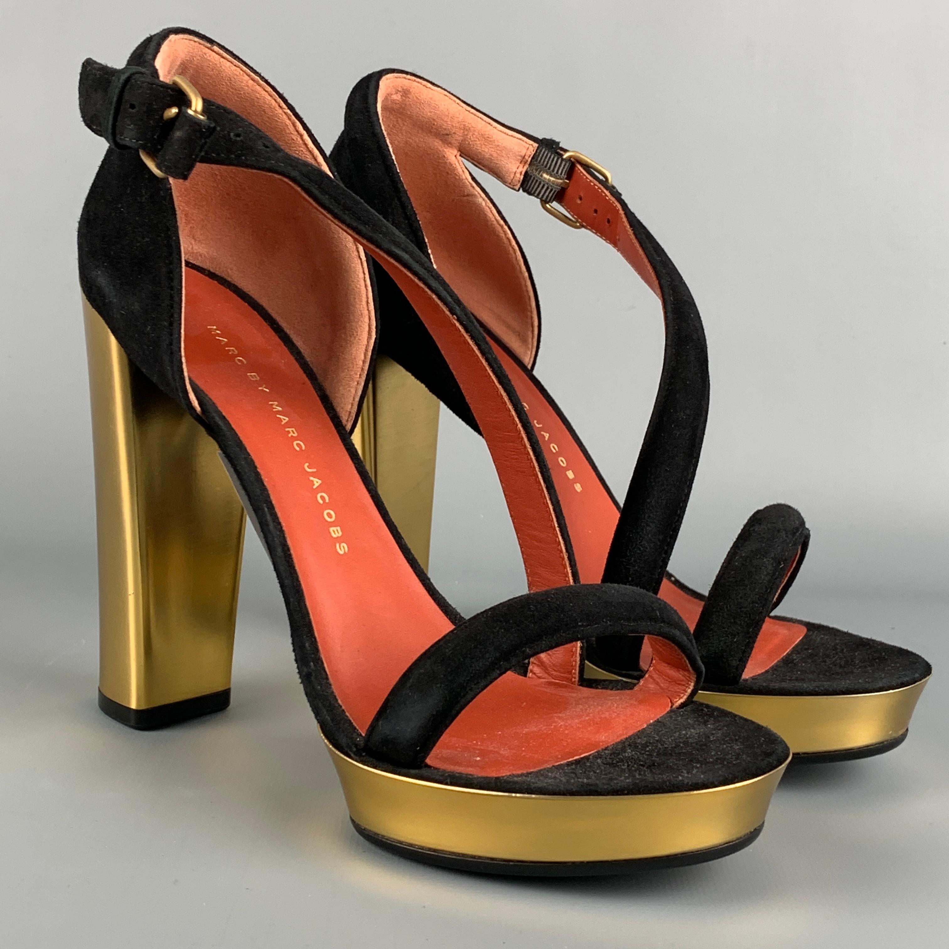 MARC by MARC JACOBS pumps comes in a black & gold leather featuring a open toe, chunky heel, and a strap buckle closure. Made in Italy. 

Very Good Pre-Owned Condition.
Marked: 36

Measurements:

Heel: 4.5 in.
Platform: 1 in. 