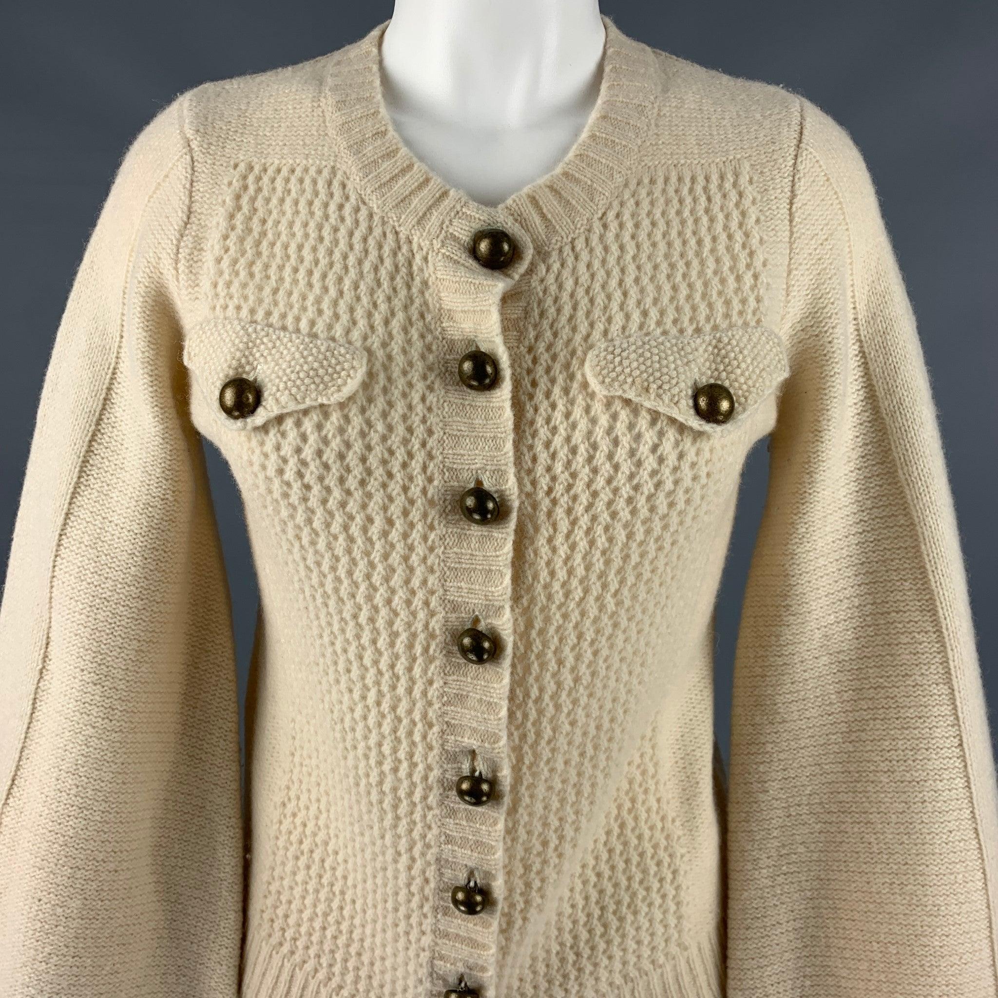 MARC JACOBS
casual top in a
cream wool knit featuring contrasting knit textures, see through front and back, large brass buttons, balloon sleeves, and a button closure.Very Good Pre-Owned Condition. Minor discoloration around buttonholes, and minor