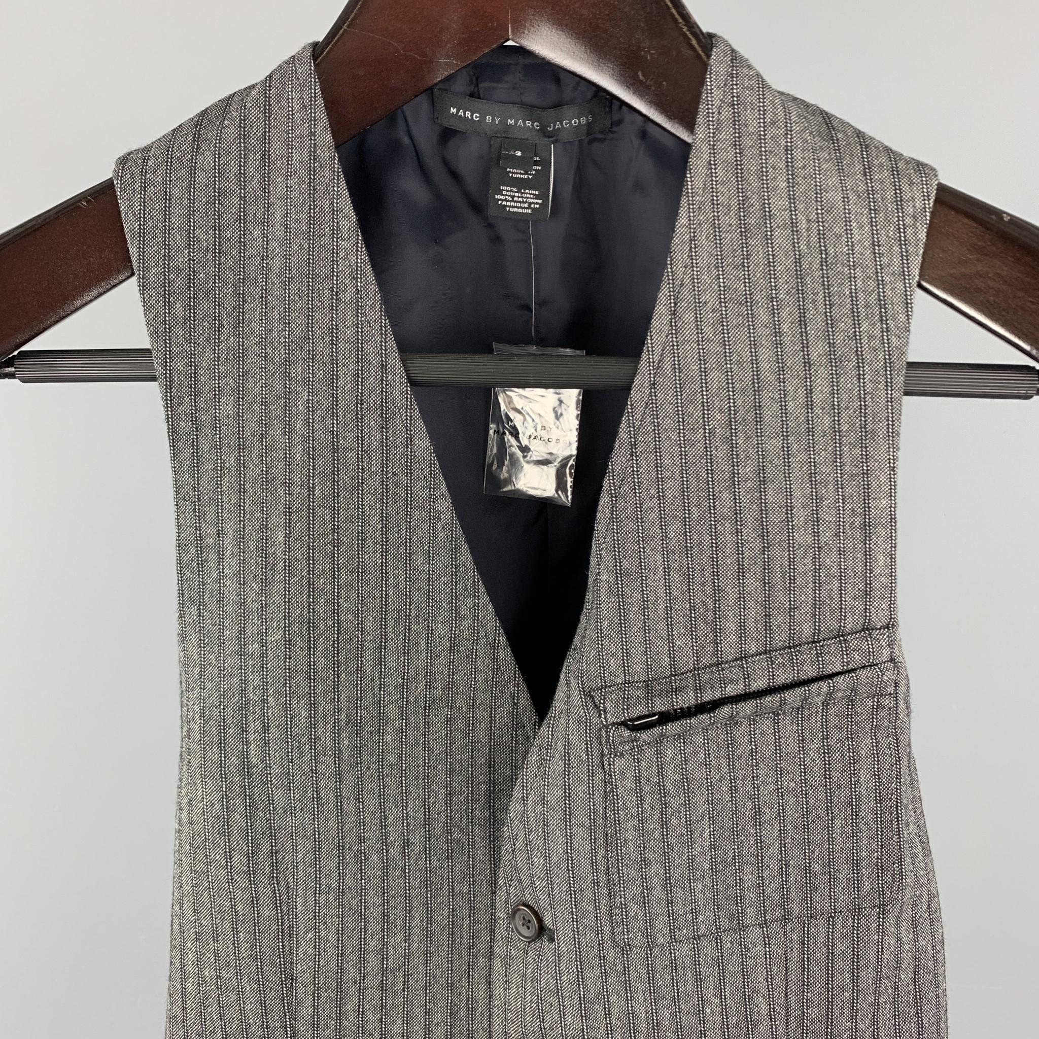 MARC by MARC JACOBS Vest comes in a gray stripe wool material, with a V-neck, a buttoned front, zip and slit pockets, and a striped back.

New without Tags.
Marked: S

Measurements:

Shoulder: 11.5 in. 
Chest: 34 in. 
Length:  24 in. 