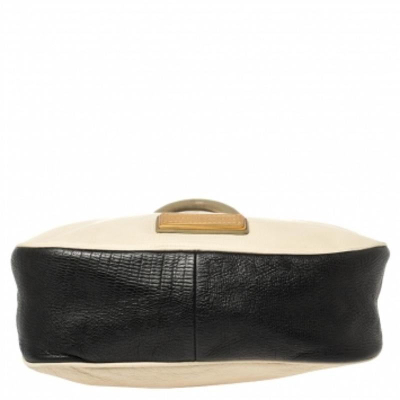 As the name goes, this magnificent tote by Marc Jacobs is surely Too Hot to Handle! It has been beautifully crafted in lizard-embossed leather in three shades and is accented with gold-tone hardware. It features double top rolled handles and a top