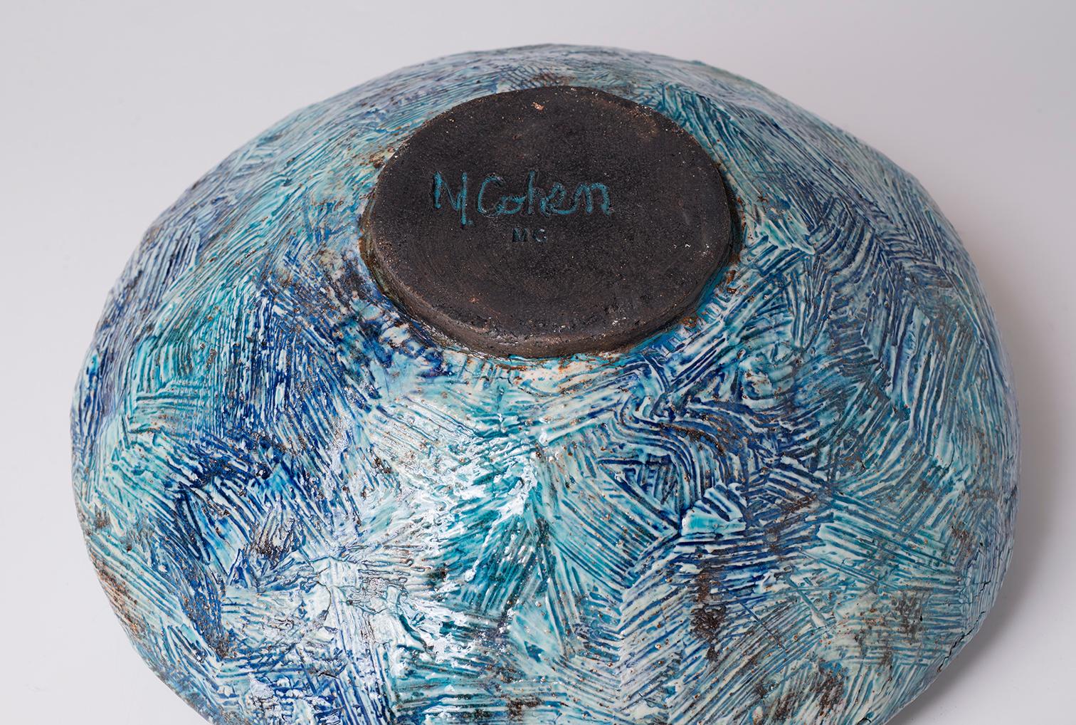 Slab built vessel with applied porcelain slip. Hand rubbed with blues and turquoise under glaze. Finished with a transparent turquoise glaze. Off white liner glaze inside.

About the Artist Marc Cohen
I love the raw and earthy properties of clay.