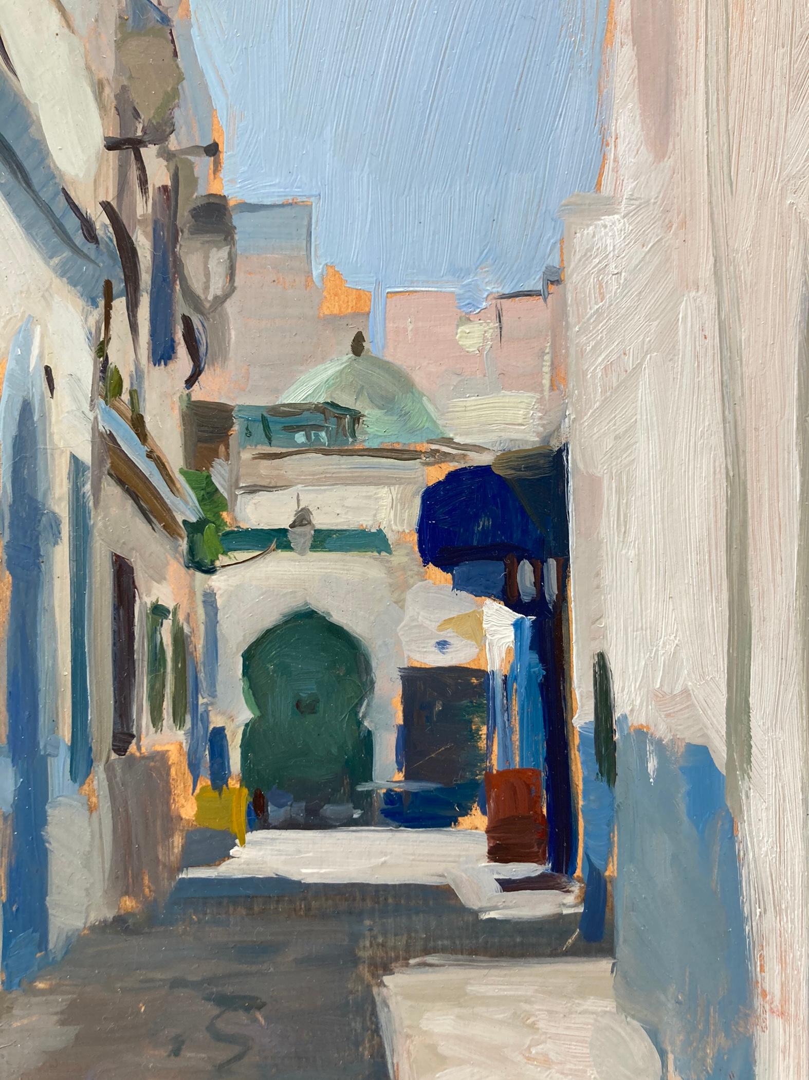 Dalessio depicts a corridored of Assilah, Morocco in this plein air painting. The paint on the buildings mirrors the color of the bright blue sky above. The style of the building at the end of the street gives away the painting's Morocco location.