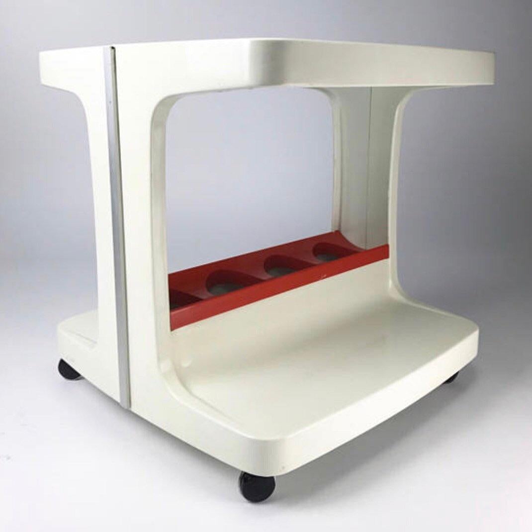 Beautiful white and orange plastic table / bar from 1970 by Marc Held.

Smoked glass on the top and two shelves divided with a tray for four large bottles below. 

This particular model comes with the original orange plastic tray which is quite