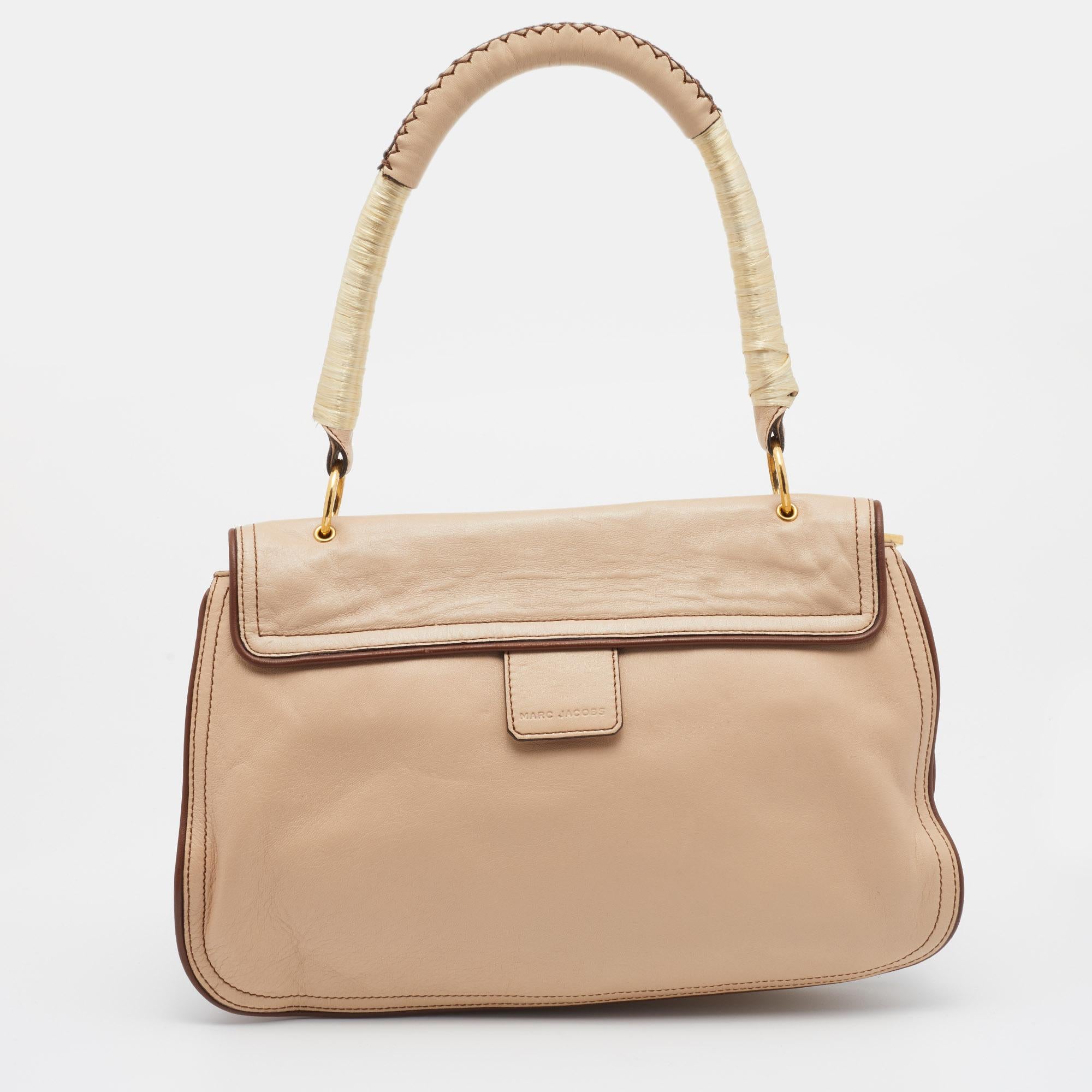 Showcase an elegant style by accessorizing your outfit with this Marc Jacobs bag. Crafted from leather, the design is highlighted with crystal-embellished closure on the front flap and is held by a single handle at the top. The satin-lined interior
