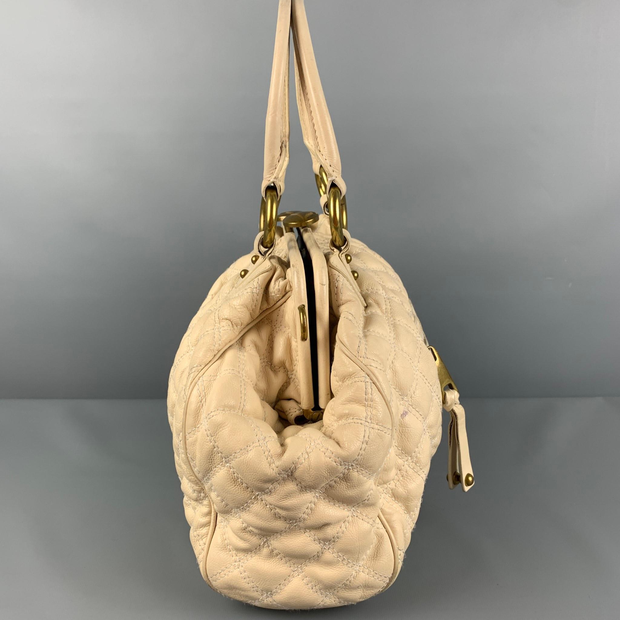 MARC JACOBS 'Stam' bag comes in a beige quilted leather featuring top handles, gold tone hardware, front zipper pocket, inner pocket, and a kiss-lock closure. 

Good Pre-Owned Condition. Moderate wear. Missing strap. As-Is.

Measurements:

Length: