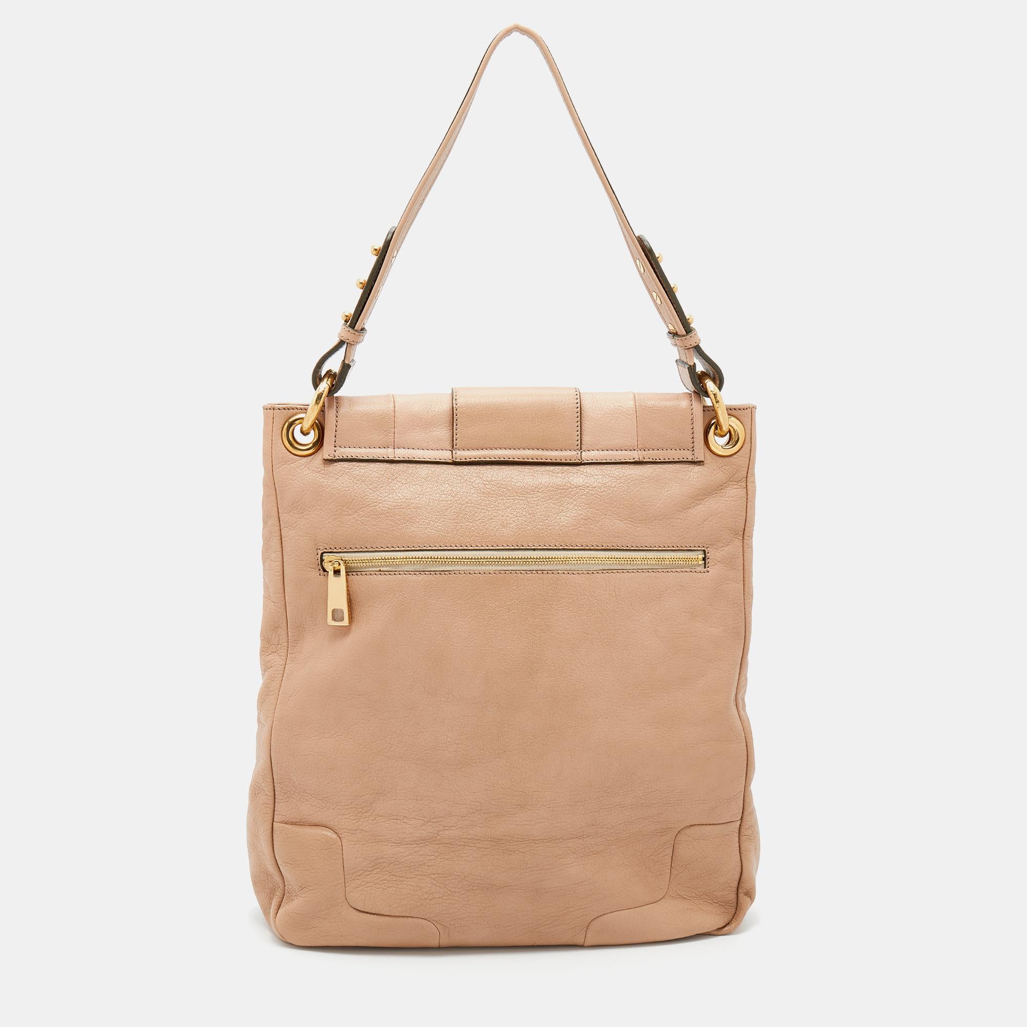 Make space in your closet for this gorgeous beige bag from Marc Jacobs. It is made from leather and comes with a stone-embellished front flap, gold-tone hardware, a shoulder strap, and a well-sized interior that can house your belongings with ease.