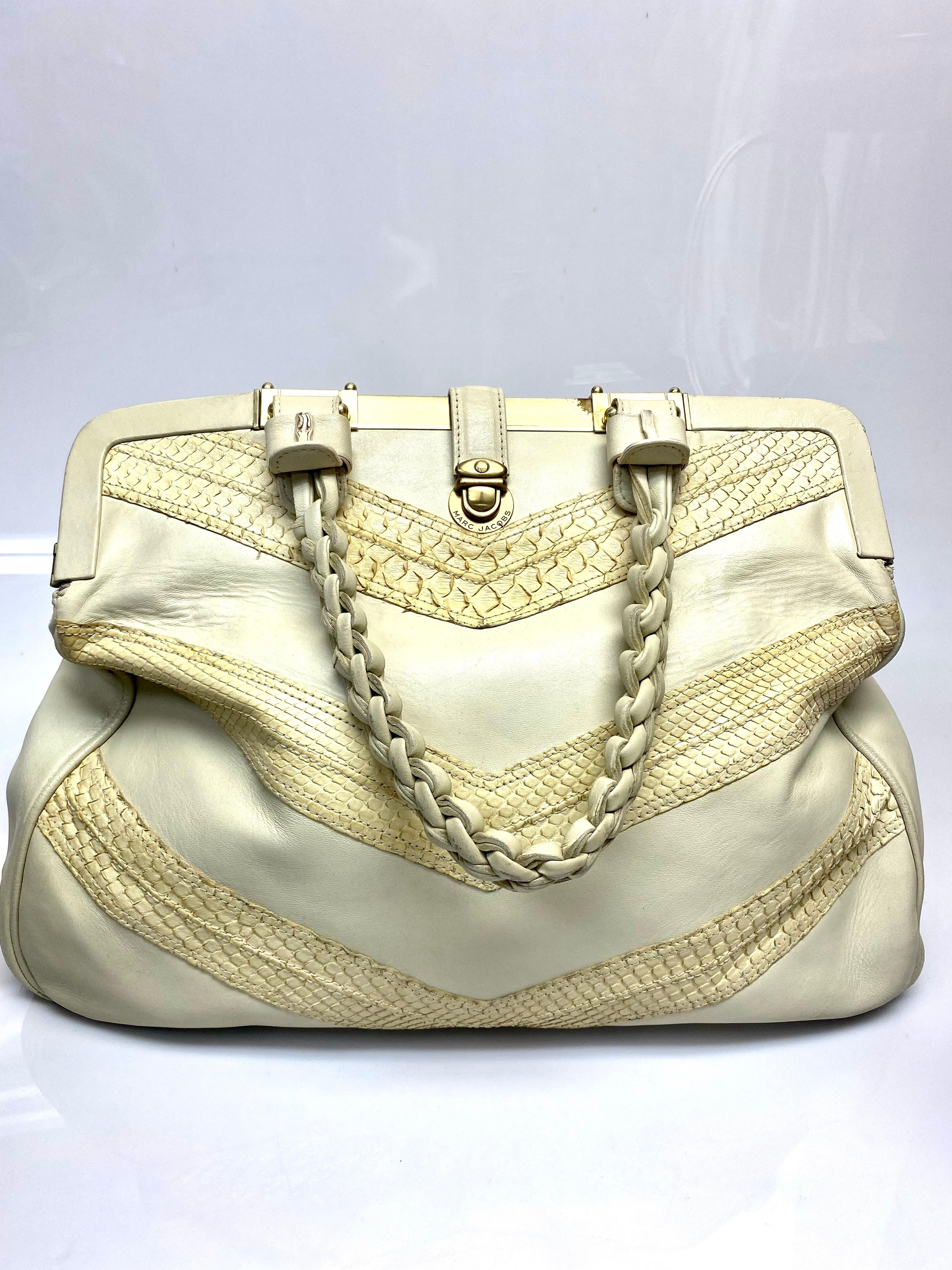 Un autre des magnifiques sacs à main de Marc Jacobs, cette beauté en cuir de python beige. L'intérieur est doublé de marron et le sac est doté de ferrures dorées et d'une pochette zippée à l'intérieur. L'article est en bon état et présente des