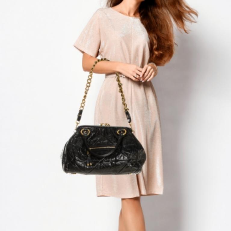 This Marc Jacobs design has a black crinkled exterior crafted from leather and enhanced with gold-tone hardware. This elegant Stam bag features a kiss-lock top closure that opens to a fabric interior, dual top handles, and a removable chain that