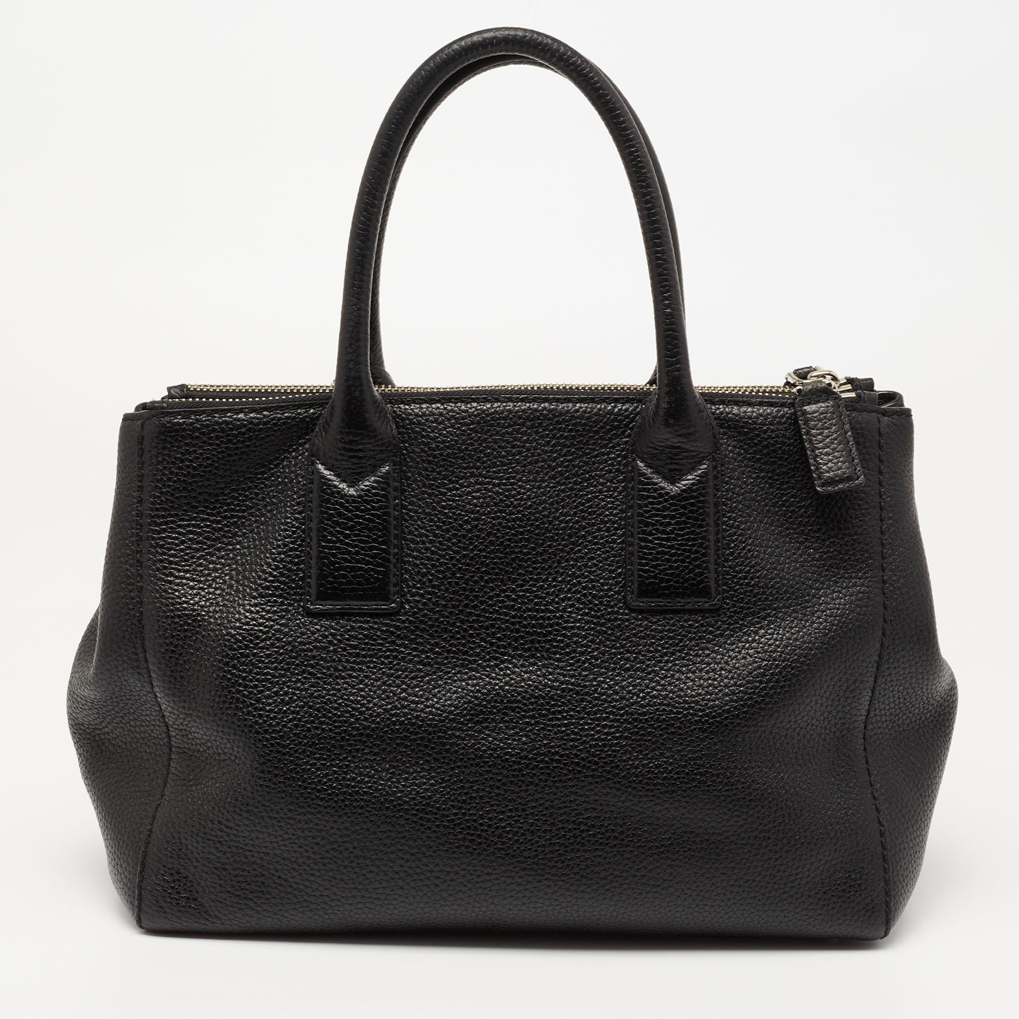 This Marc Jacobs tote promises to take you through the day with ease, whether you're at work or out and about in the city. From its design to its structure, the black leather bag promises charm and durability. It has dual top handles, an optional