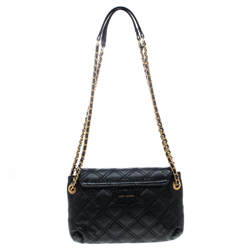 This sleek piece in black from Marc Jacobs is excellent for all your outings. Crafted from canvas the bag features a quilted exterior and a bow adornment on the front flap. It comes with dual chain-canvas handles and a fabric lined