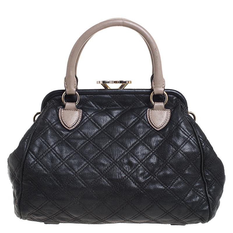 This Marc Jacobs Stam satchel is crafted from leather and features a quilted pattern on the exterior. The bag has a kiss lock closure, dual handles, a front zip pocket with a push button, protective metal feet and a detachable chain strap with