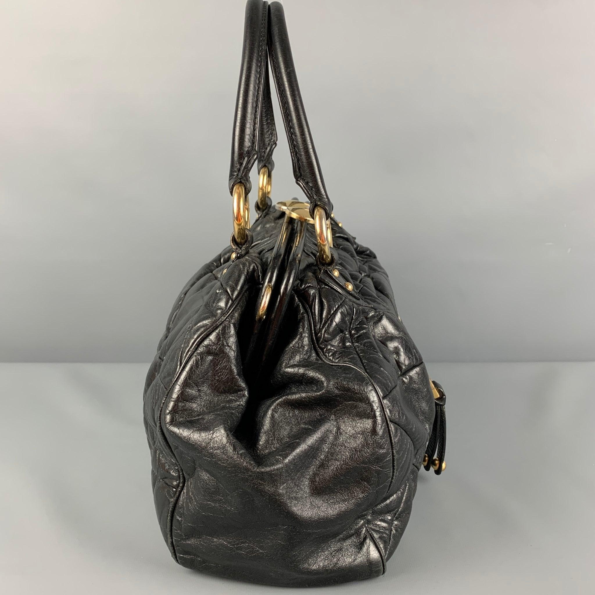 MARC JACOBS 'Stam' bag comes in a black quilted leather featuring top handles, gold tone hardware, front zipper pocket, inner pocket, and a kiss-lock closure.
Good
Pre-Owned Condition. Moderate wear. Missing strap. As-Is.  

Measurements: 
  Length:
