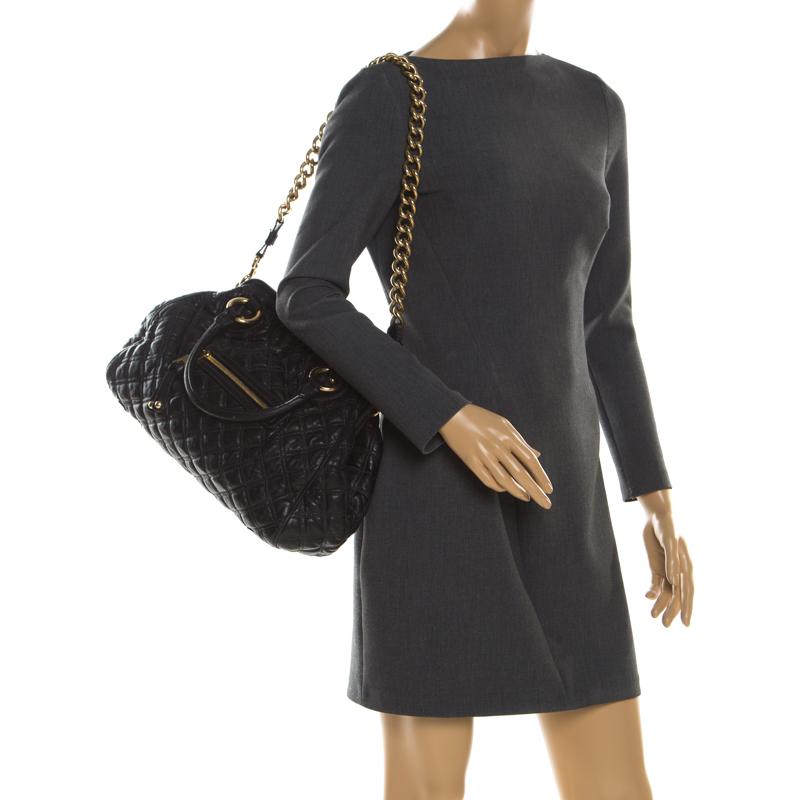 This Marc Jacobs piece has a black quilted exterior crafted from leather and enhanced with gold-tone hardware. The elegant Stam bag features a top lock closure that opens to a fabric interior, designed with a small coin pocket. It comes with dual