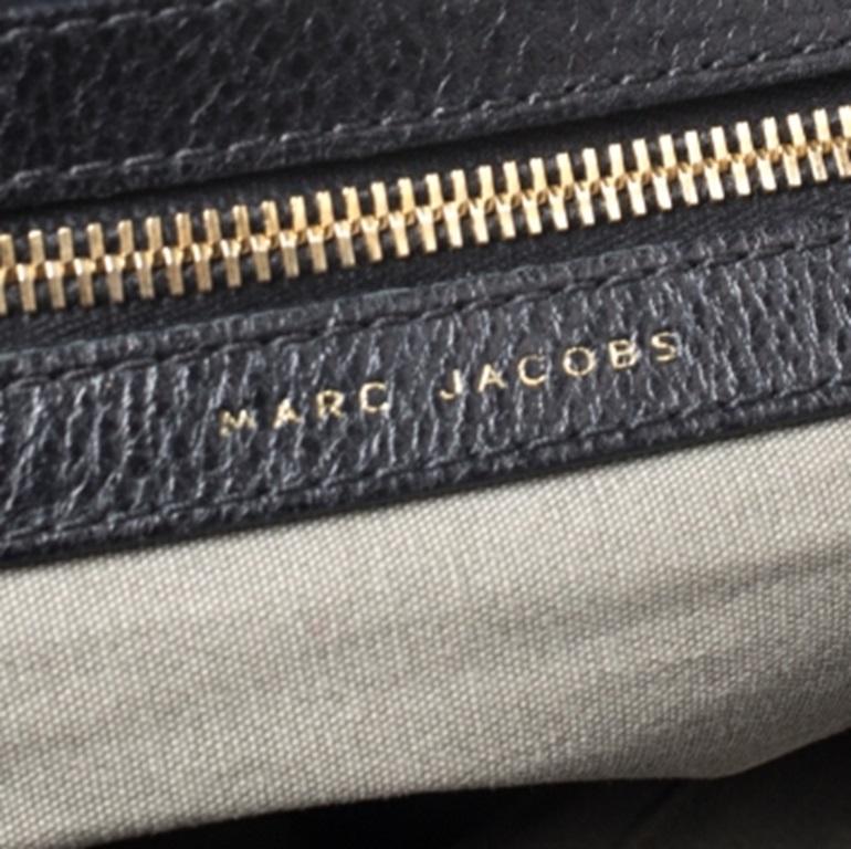 Unbestritten stilvoll und brillant im Design ist diese schwarze Tasche von Marc Jacobs. Die aus schlangenhautgeprägtem Leder gefertigte Tasche hat eine gesteppte Außenseite und ein Vorhängeschloss auf der Vorderseite. Das mit Segeltuch gefütterte