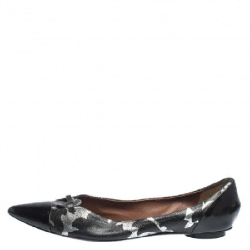 Ces superbes ballerines Marc Jacobs sont absolument indispensables. Elles sont fabriquées en cuir verni et en cuir d'aluminium et se déclinent en noir et en argent. Elles sont dotées d'un bout pointu, d'un petit nœud et d'une semelle en cuir.