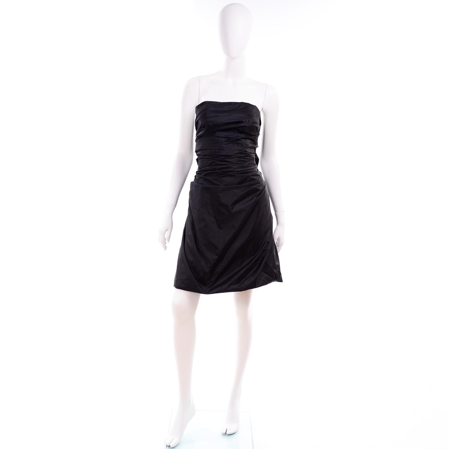 This is a great vintage Marc Jacobs evening dress from the early 2000's. The dress is in an elevated, rich black taffeta with an open back that closes with attached fabric ties.  This punk inspired vintage has a corset bra like closure at the back