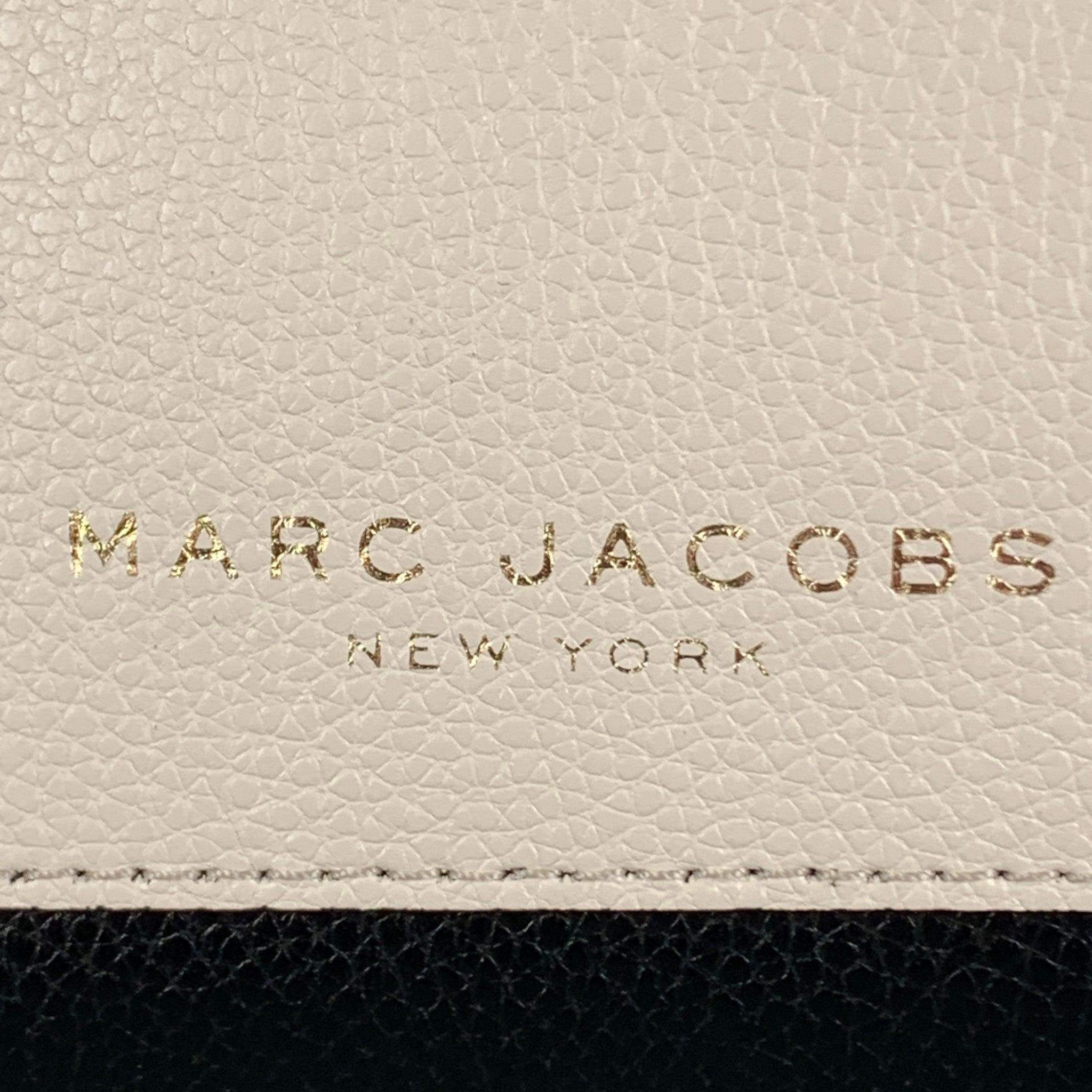 MARC JACOBS clutch comes in a beige black and tan textured leather featuring a color block style, outside patch pocket, and gold tone zip up closure. New with Tags Pre-Owned Condition. 

Measurements: 
  Length: 7.5 inches Width:
2.5 inches Height:
