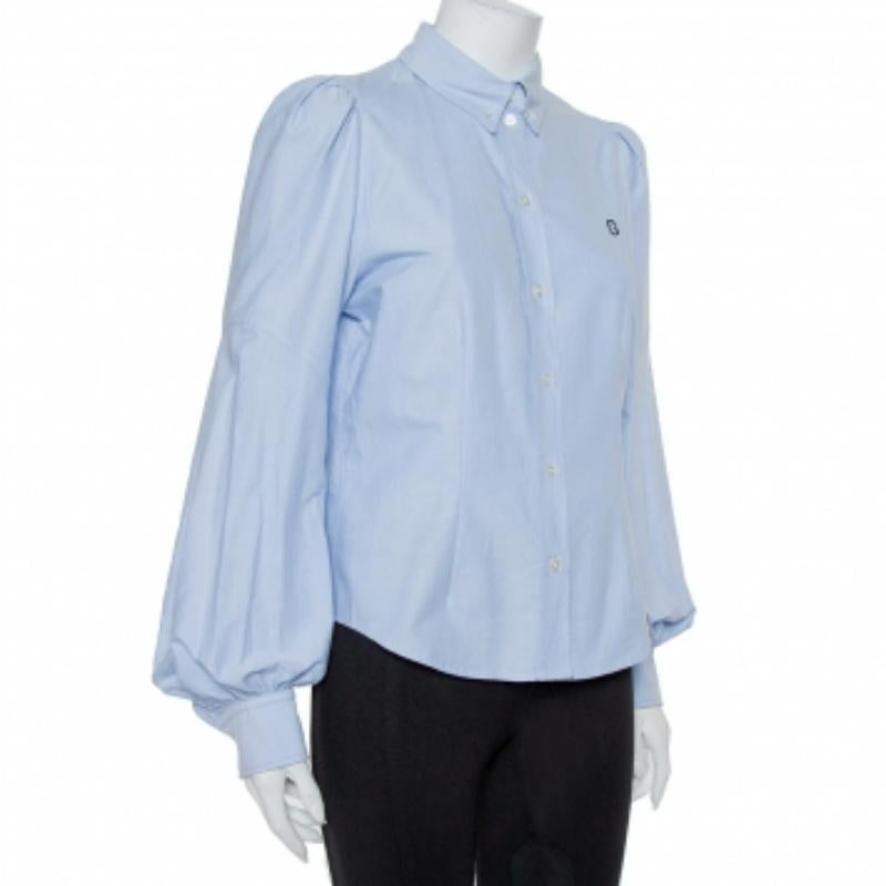 Quando mai le creazioni di Marc Jacobs non ci hanno colpito? Lo fanno sempre e questa fantastica camicia ne è la prova! Questa creazione in cotone blu ha un design a pannelli e presenta una chiusura frontale con bottoni e maniche lunghe a sbuffo.