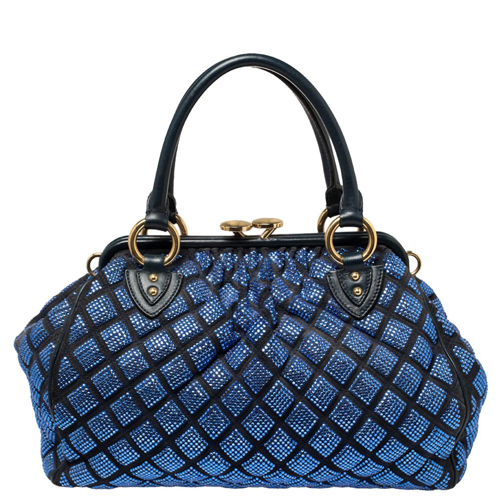 This Marc Jacobs design has a blue quilted exterior crafted from suede and leather enhanced with crystals and gold-tone hardware. This elegant Stam bag features a kiss-lock top closure that opens to a satin interior, dual top handles, and a