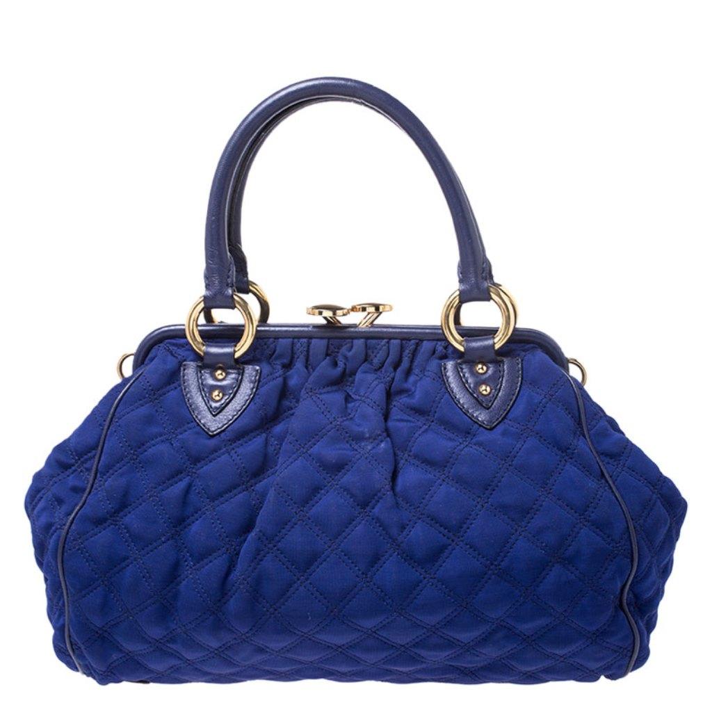 This Marc Jacobs design has a blue quilted exterior crafted from neoprene and leather and enhanced with gold-tone hardware. This elegant Stam bag features a kiss-lock top closure that opens to a fabric interior, dual top handles and a removable