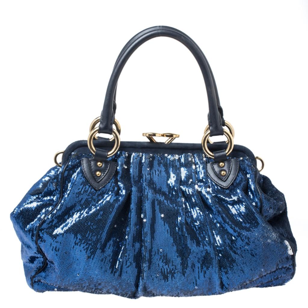 This Marc Jacobs design has a blue exterior crafted from sequin and enhanced with gold-tone hardware. This elegant Stam bag features a kiss-lock top closure that opens to a satin interior, dual top handles and a removable chain that converts this