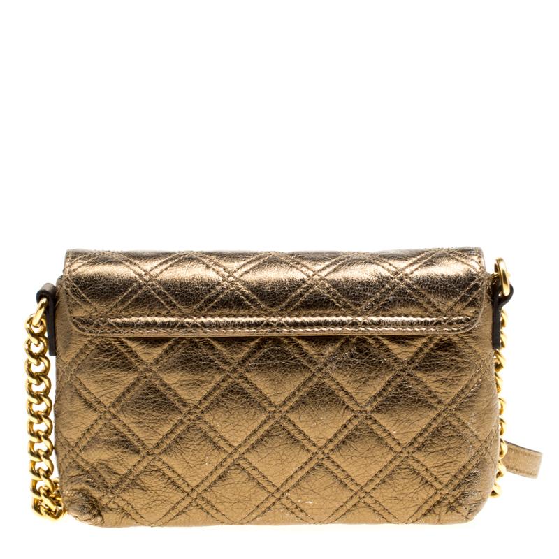 This Marc Jacobs Day To Night crossbody bag can be carried during the day or night, as the name suggests. Crafted from bronze leather, this bag features a quilted exterior and a push lock detail on the flap. It is held by a shoulder strap. Its
