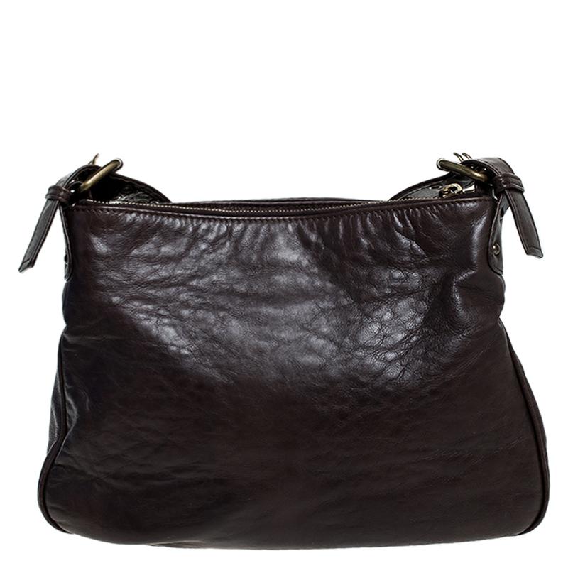 A functional bag like this one from Marc Jacobs updates your style and lends a contemporary look. Crafted from brown leather, the bag features a zip pocket and two buckled pockets on the front. It is held by a shoulder strap and the interior is