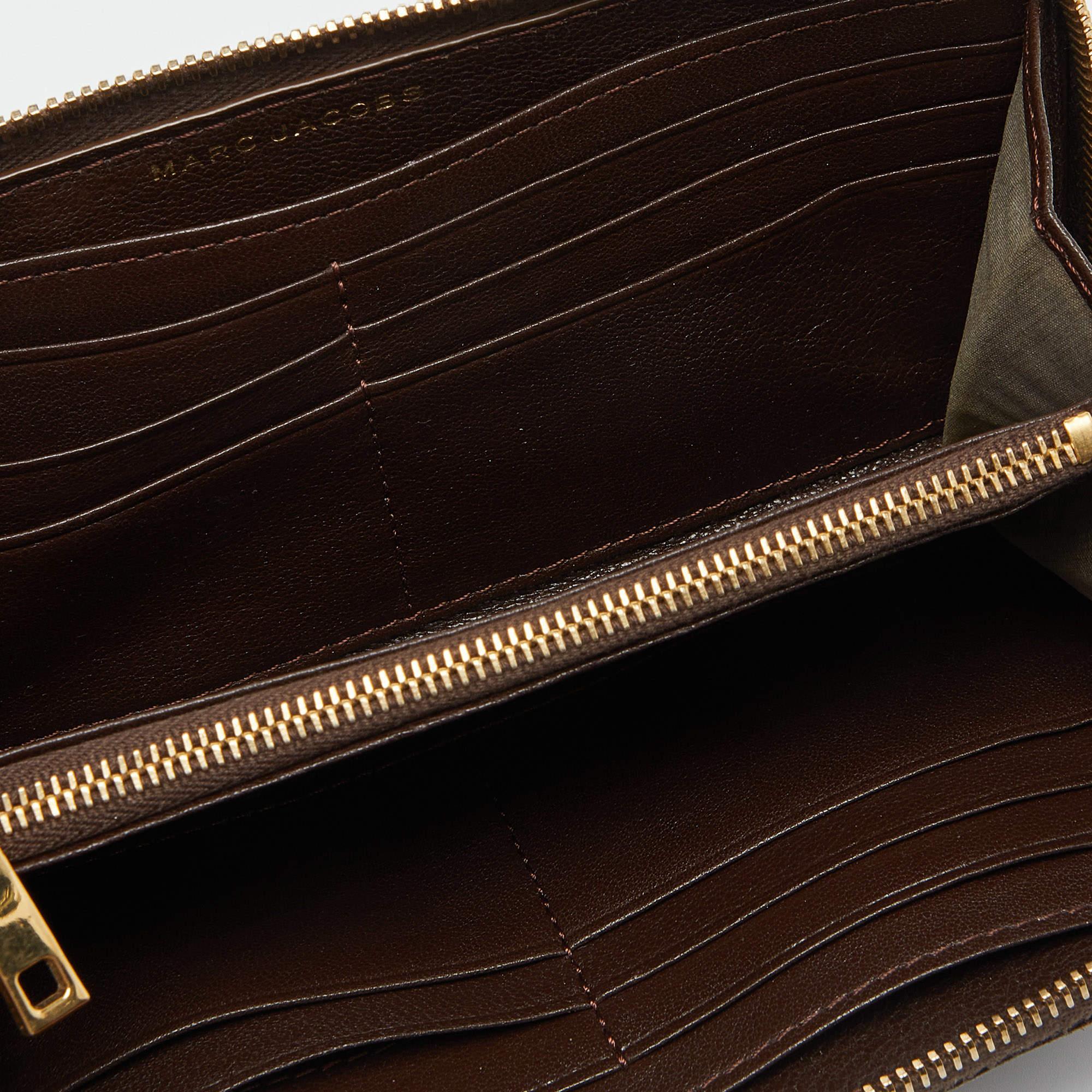 This simple wallet from Marc Jacobs is crafted from quilted leather. Brown in color the zipped wallet opens to a leather and fabric lined interior. The wallet features multiple open compartments.