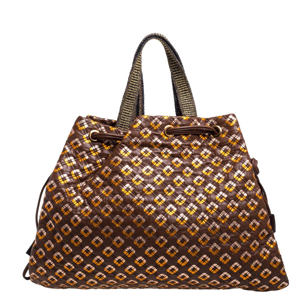 Striking and unique, this Marc Jacobs Memphis tote will add character to any look! Featuring a brown & rose gold leather body, this bag is coupled with a stitched quilted design. This tote also has three leather tassels, a gold-tone Marc Jacobs