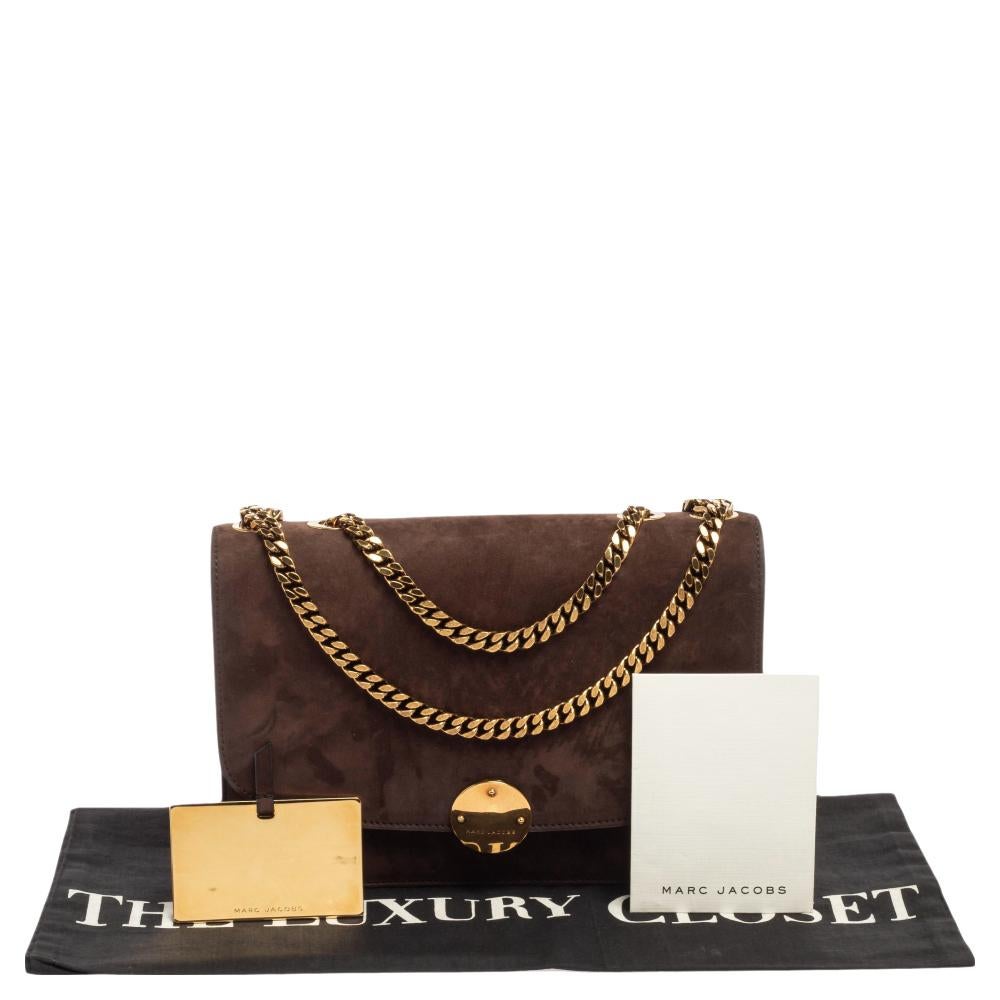 Flaunt this Marc Jacobs shoulder bag like a fashionista! Crafted from understated brown suede, this Trouble bag has a structured and stylish silhouette that will go well with your party looks. It features a front flap adorned with a gold-tone lock