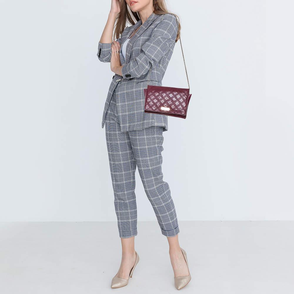 Grab this stylish and versatile clutch bag from the house of Marc Jacobs. It has been crafted from quilted leather and comes in a lovely shade of burgundy. The front flap has a logo detail and opens to a  fabric interior with a zip pocket, slots,