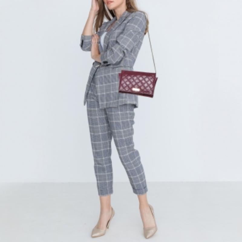 Grab this stylish and versatile clutch bag from the house of Marc Jacobs. It has been crafted from quilted leather and comes in a lovely shade of burgundy. The front flap has a logo detail and opens to a  fabric interior with a zip pocket, slots,