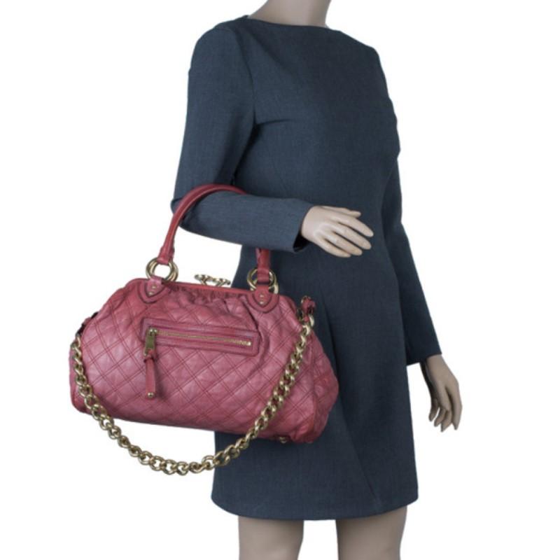 This Marc Jacobs cherry red leather bag is cool, calm and collected but with style. The red leather definitely makes a fashion statement, along with the classic quilted pattern and eye-catching gold tone hardware. The exterior includes a front zip