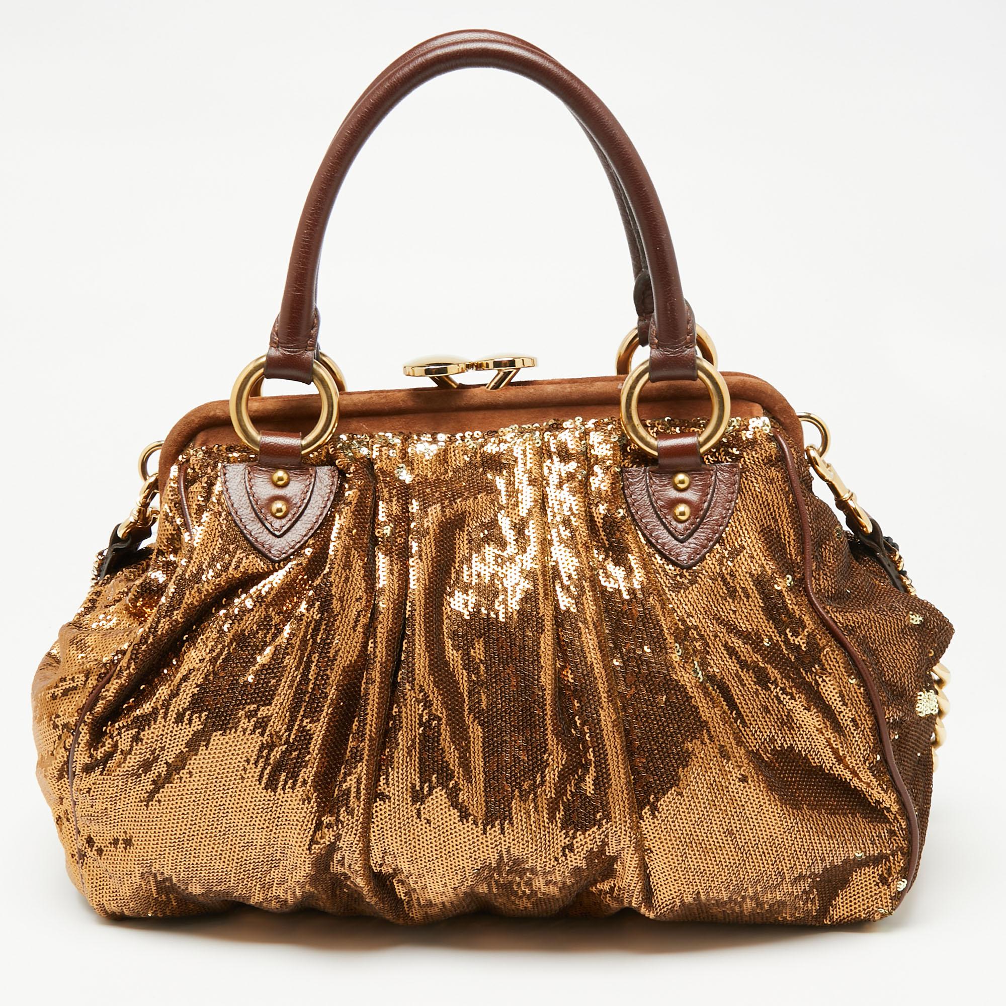 This Marc Jacobs design has a gleaming exterior covered in sequins and matched with gold-tone hardware, brown leather, and brown suede. The elegant Stam bag has a kiss-lock top closure, a satin interior, dual top handles, and a removable chain that