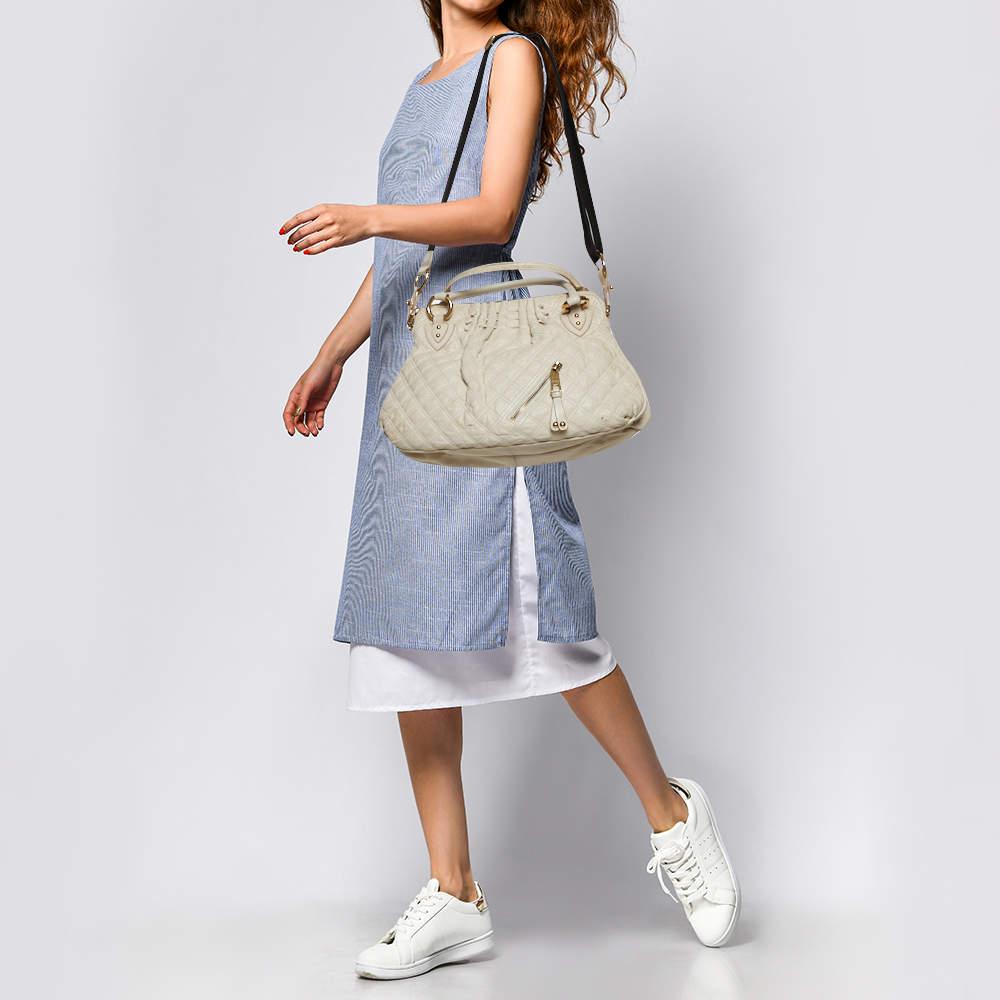 A functional design unique details and timeless appeal make this Cecilia satchel from Marc Jacobs a worthy addition to any womens closet. Crafted from cream quilted leather it has been styled with a zip detailing on the front. A zip top closure
