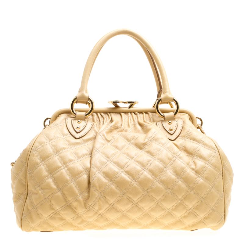 This Marc Jacobs design has a quilted exterior crafted from leather and gold-tone hardware. The elegant Stam bag features a kiss-lock top closure that opens to a fabric interior, a front zipper, dual handles and a shoulder chain. Swing this beauty