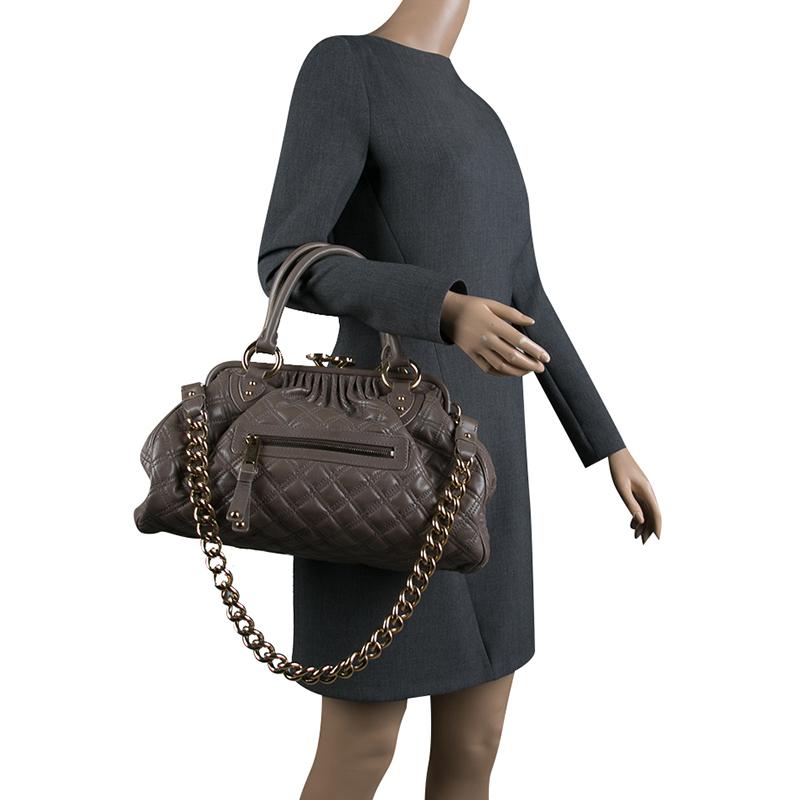 This Marc Jacobs design has a dark beige quilted exterior crafted from leather and gold-tone hardware. The elegant Stam bag features a kiss-lock top closure that opens to a fabric interior, a front zipper, dual handles and a shoulder chain. Swing