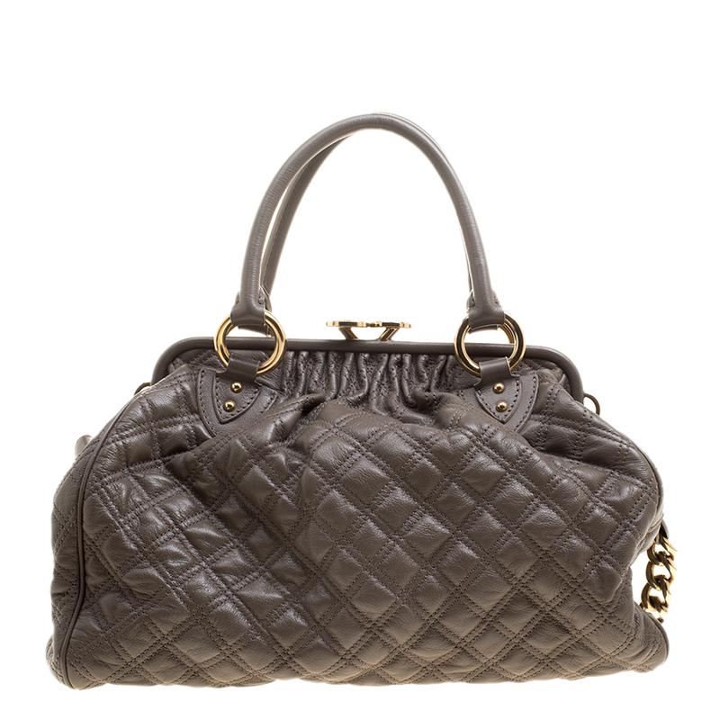 This Marc Jacobs design has a dark beige quilted exterior crafted from leather and gold-tone hardware. The elegant Stam bag features a kiss-lock top closure that opens to a fabric interior, a front zipper, dual handles and a shoulder chain. Swing