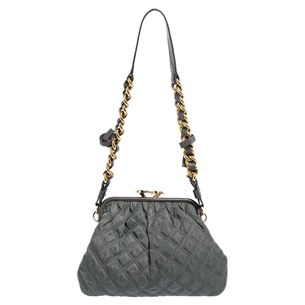 This Marc Jacobs design has a grey quilted exterior crafted from fabric and enhanced with gold-tone hardware. This elegant Stam bag features a kiss-lock top closure that opens to a fabric interior, dual top handles, and a removable chain that