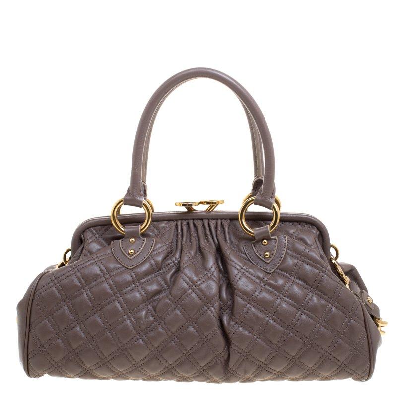 This Marc Jacobs Stam satchel is crafted from leather and features a quilted pattern on the exterior. The bag has a lock closure, dual handles, two front zip pockets, protective metal feet and a detachable chain strap. The fabric lined interior