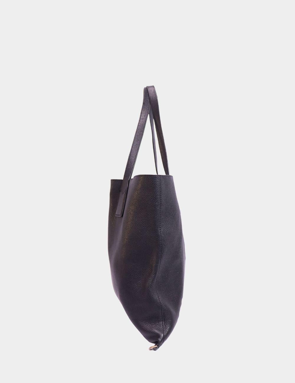 Elevate your everyday with this Marc Jacobs Black Leather Tote, a minimal yet functional essential for work, errands, or travel. Crafted from rich pebbled leather, it features a clean square silhouette, long shoulder straps, and a subtle logo stamp