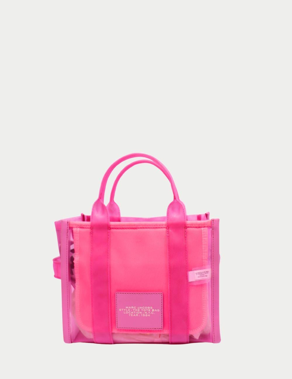 Atrae todas las miradas con este vibrante bolso tote rosa caramelo de Marc Jacobs, un toque divertido y moderno del bolso de mano de todos los días. Fabricada en PVC transparente con una bolsa de tela rosa a juego, esta bolsa es a la vez funcional y