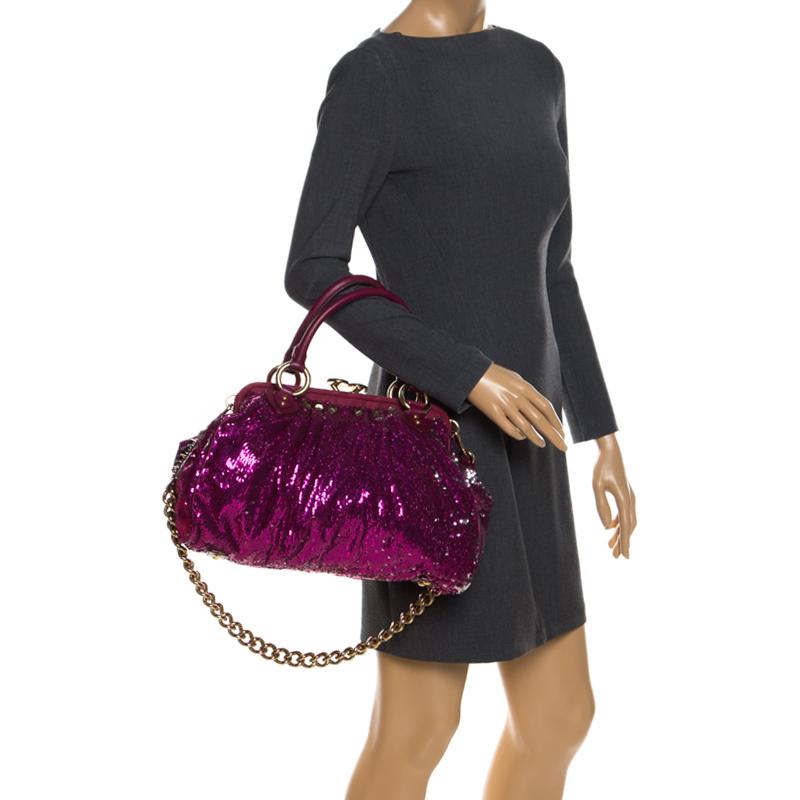 This Marc Jacobs design has a fuchsia exterior crafted from sequins, suede and leather and enhanced with gold-tone hardware. This elegant Stam bag features a kiss-lock top closure that opens to a satin interior, dual top handles and a removable