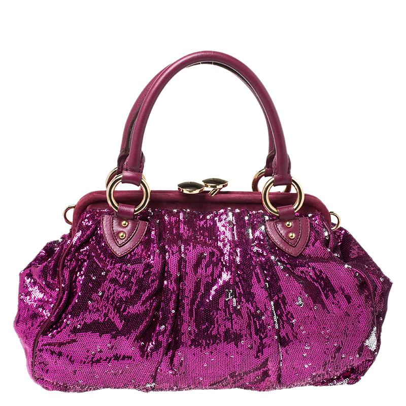 This Marc Jacobs design has a fuchsia exterior crafted from sequins, suede and leather and enhanced with gold-tone hardware. This elegant Stam bag features a kiss-lock top closure that opens to a satin interior, dual top handles and a removable