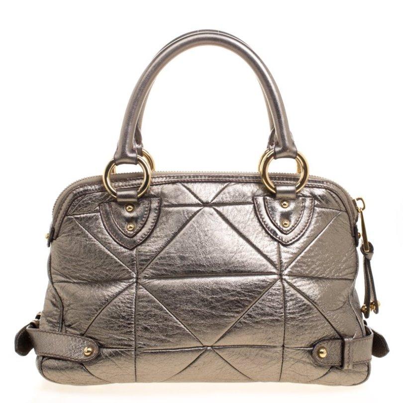 Carry this gorgeous Marc Jacobs creation wherever you go and make people drool. Meticulously crafted from leather, this satchel has been styled with quilt patterns all over its exterior. It is equipped with dual handles, protective metal feet, and a