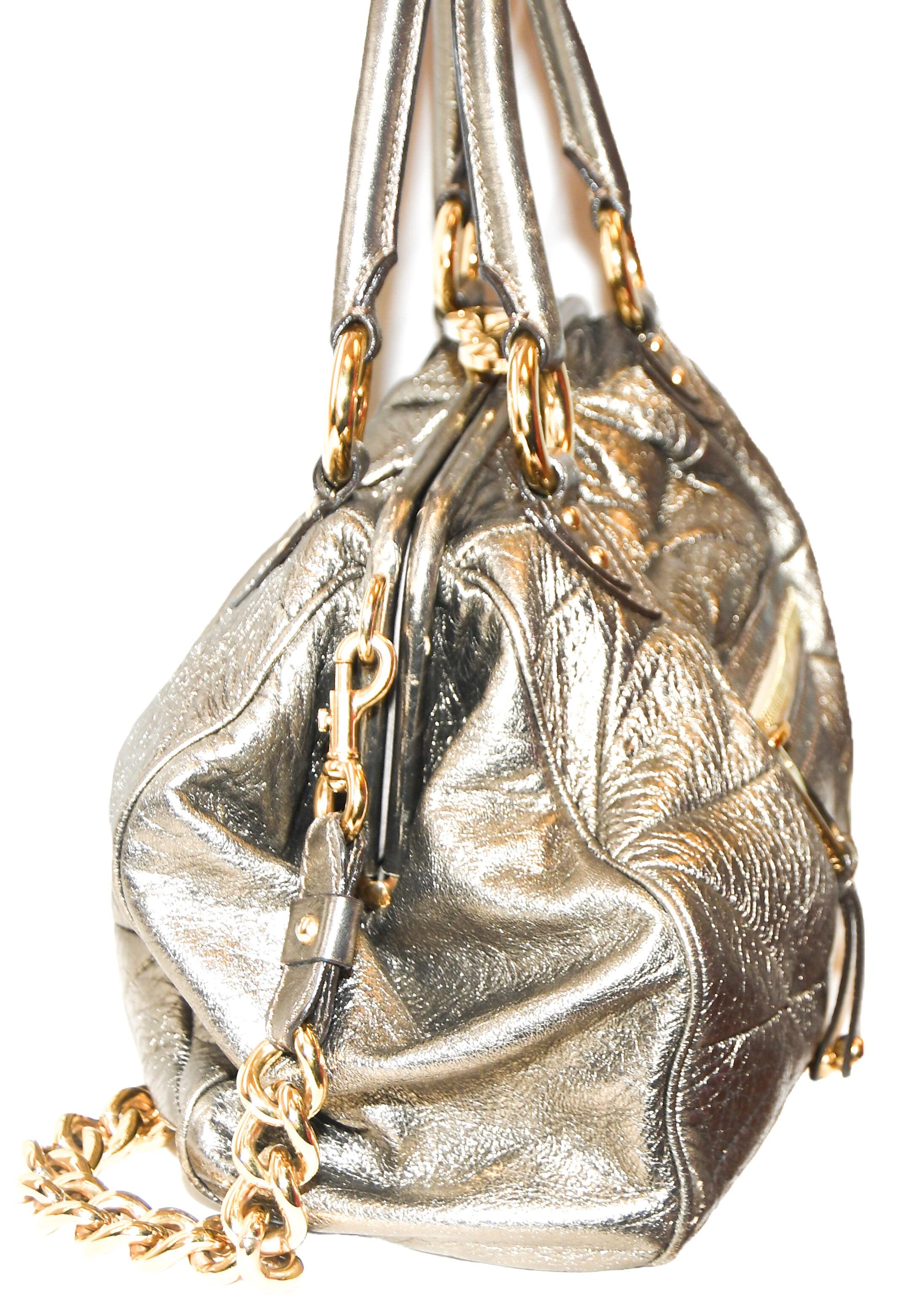 Marc Jacobs Metallic gold tone quilted leather bag has gold tone hardware.  This bag incorporates two rolled top handles and a single detachable gold chain link shoulder strap.  With an exterior zippered pocket for easy access for your keys and