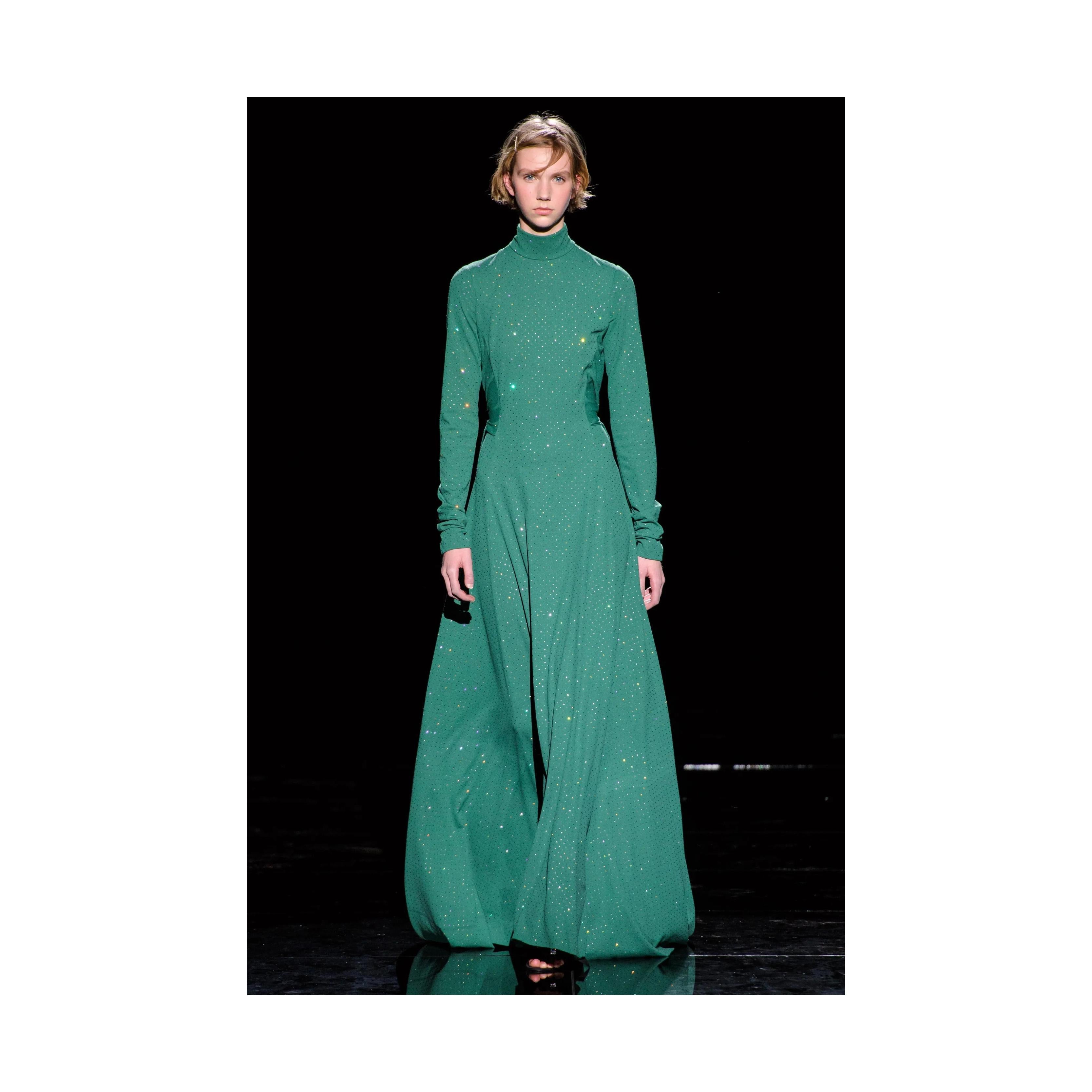 This stunning Marc Jacobs gown features a traditional long and flowy design with small crystal balls that subtly glimmer in the light. It also has an exaggerated feature of two long panels from the waist down that can be tied at the back, adding a