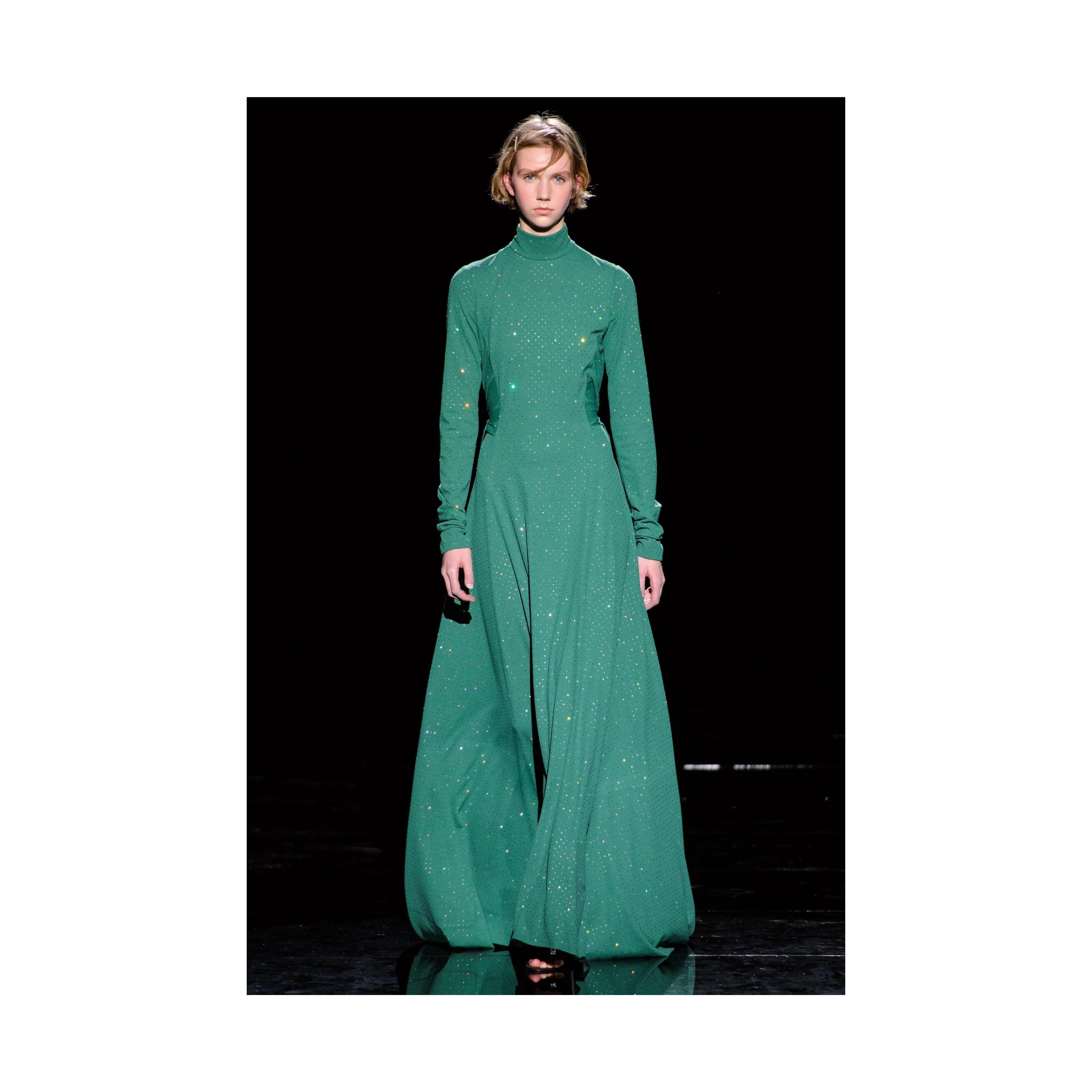 Este impresionante vestido de Marc Jacobs presenta un diseño tradicional largo y fluido con pequeñas bolas de cristal que brillan sutilmente con la luz. También tiene una característica exagerada de dos paneles largos de cintura para abajo que se