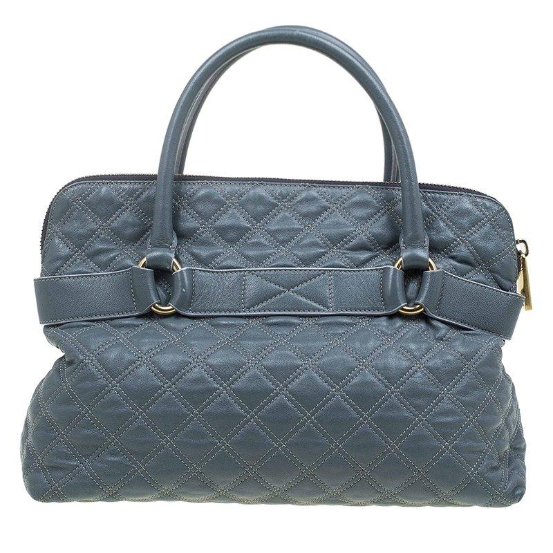 This Marc Jacobs Bruna tote is made from leather and has a belt accent. Dual, rolled top handles and a spacious main compartment allow you to carry your essentials. The interior is lined with fabric and has a zipper closure. An open pocket makes