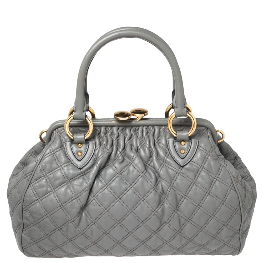 This Marc Jacobs design has a grey quilted exterior crafted from leather and enhanced with gold-tone hardware. This elegant Stam bag features a kiss-lock top closure that opens to a fabric interior, dual top handles, and a removable chain that